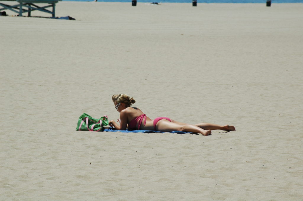 Podróż do Los Angeles. Ponętna plażowiczka na pustej plaży. 